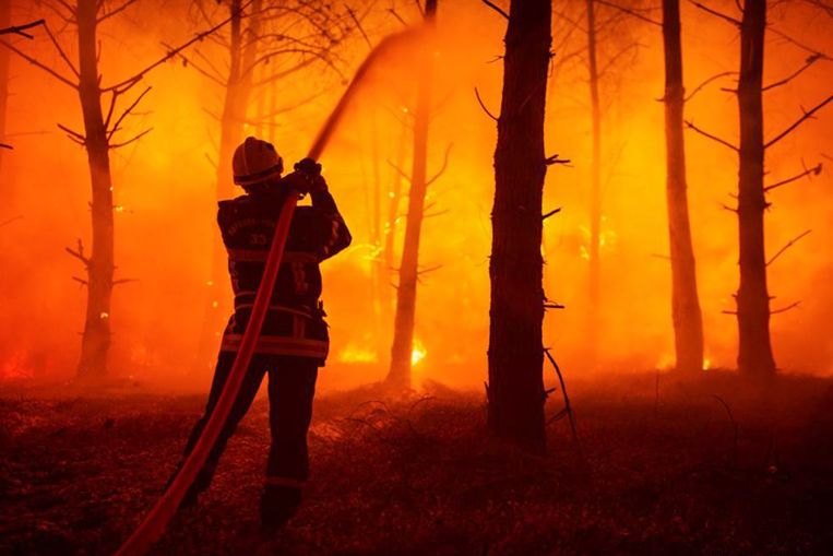 Een brandweerman in La-Teste-de-Buch in Frankrijk tracht bosbranden te blussen.  Beeld ANP / EPA