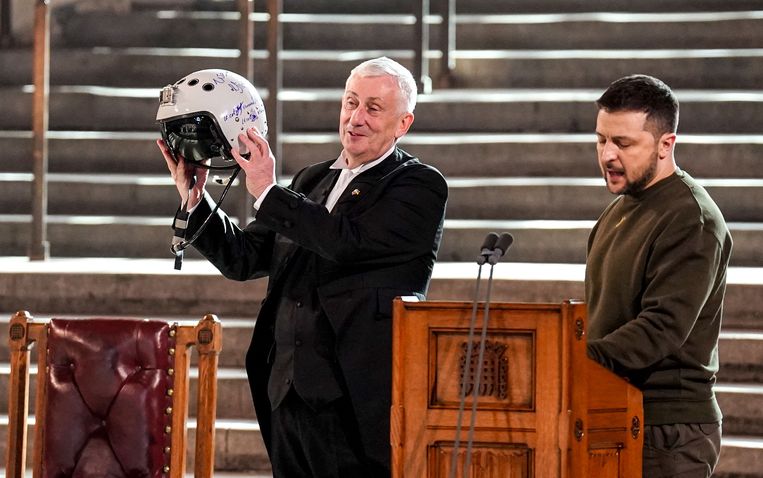 Lagerhuisvoorzitter Lindsay Hoyle toont de pilotenhelm die hij van president Zelensky kreeg overhandigd. Beeld AFP