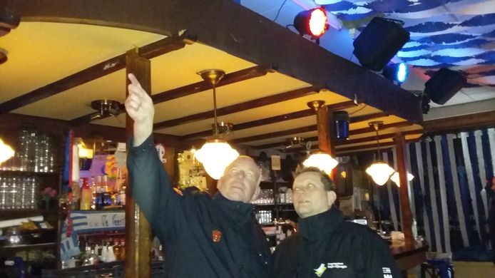 Namens de brandweer neemt Ben Maassen (links) de feestversiering in 't Nimweegs Feestcafé aan de Bloemerstraat onder de loep.