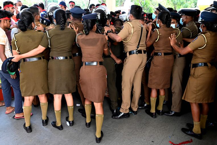 Sri Lankaanse politie-agenten proberen studenten geneeskunde tegen te houden die bij het ministerie van volksgezondheid in Colombo protesteren tegen de economische crisis die de eilandstaat teistert.  Beeld AFP