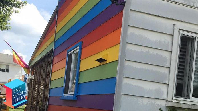 Lesbisch koppel schildert zijgevel in regenboogvlag na pesterijen.