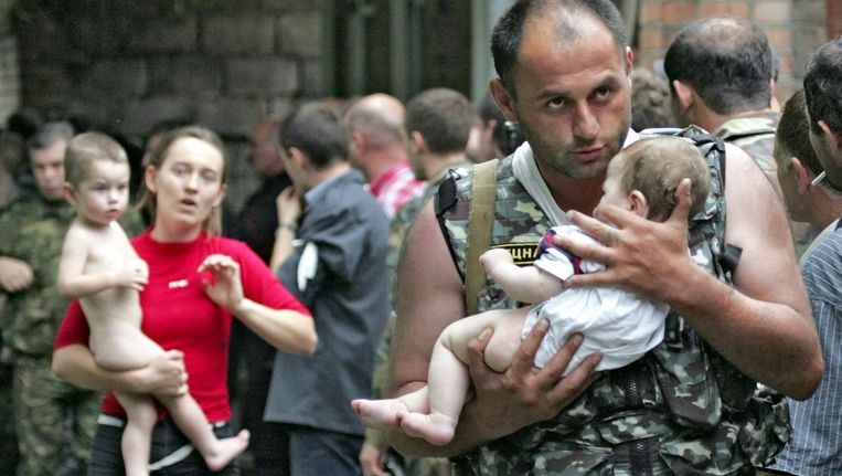 Een soldaat redt een baby uit de bezette school in Beslan, september 2004. Bij de terreuractie komen uiteindelijk honderden mensen, voornamelijk kinderen om het leven. Beeld ANP