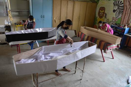 Medewerksters van een begrafenisonderneming vervaardigen doodskisten in de Indiase stad Secunderabad.
