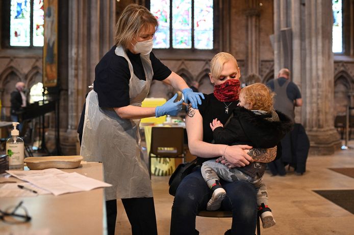 Beeld van de vaccinatiecampagne in het Verenigd Koninkrijk. Een vrouw krijgt in de tot vaccinatiecentrum omgetoverde kathedraal van Lichfield een prikje met het AstraZeneca-vaccin.