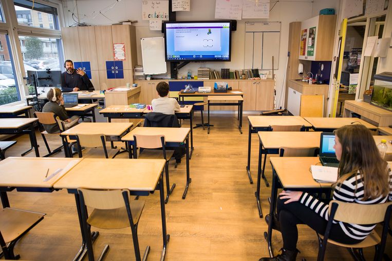 Meester Steven geeft online les aan groep 8 vanuit de klas. Drie kinderen zijn wel op school een vanwege slechte wifi en eentje heeft er extra hulp nodig. Beeld Arie Kievit / de Volkskrant