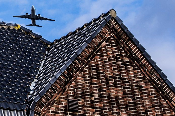 Een vliegtuig vliegt over een huis in de omgeving van Schiphol, een van de drukste luchthavens van Europa.