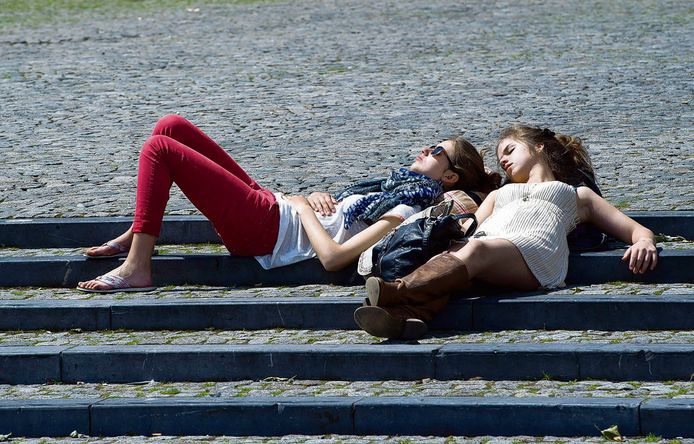 Twee meisjes genieten van de zon op het Vrijthof in Maastricht.