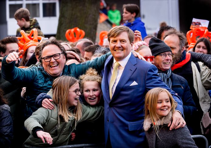 Koning Willem Alexander die twee meisjes verrast met een omhelzing in Zwolle (2016), met rechts zijn dochter Ariane. ,,Een symbolisch moment voor wat Koningsdag nu is. Het is een verbindende dag’’, vindt royaltywatcher Justine Marcella.