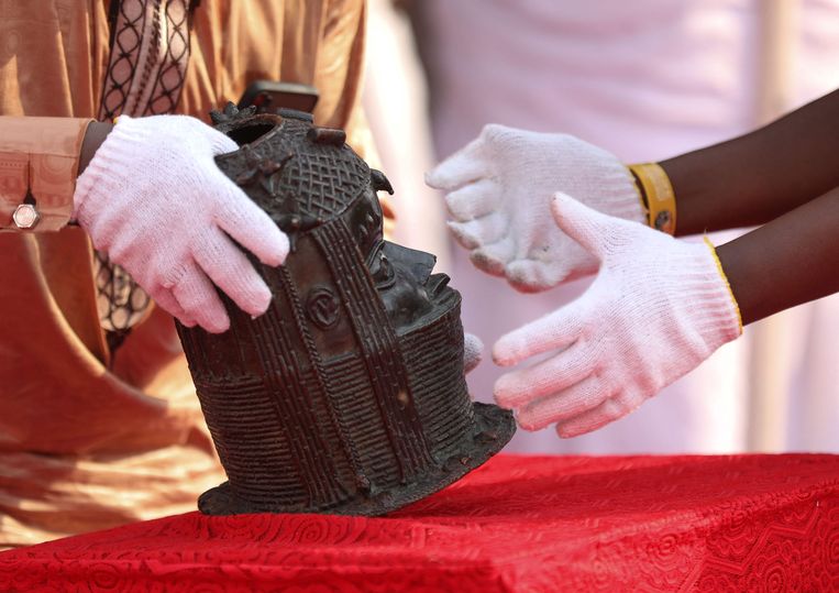 Een buste wordt teruggeplaatst in het Oba-paleis in Benin City, Nigeria. Het is een van de kunstwerken die meer dan 125 jaar geleden werden geroofd door Britse militairen in het toenmalige koninkrijk Benin. Beeld AFP