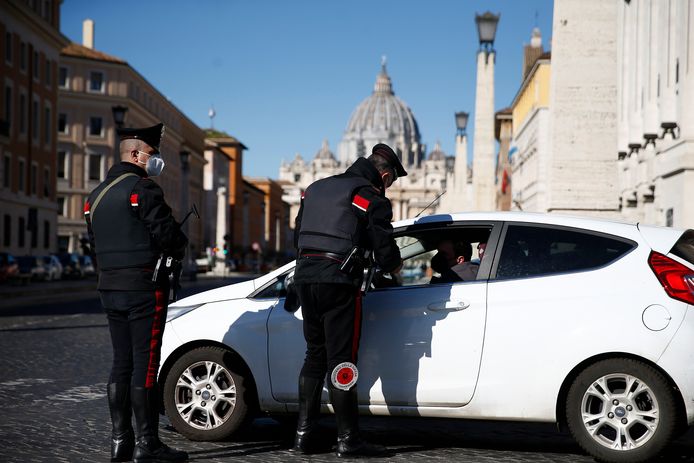 De Italiaanse politie stopt een auto in Rome vandaag. De bewegingsvrijheid in de nieuwe rode zones wordt ernstig ingeperkt.
