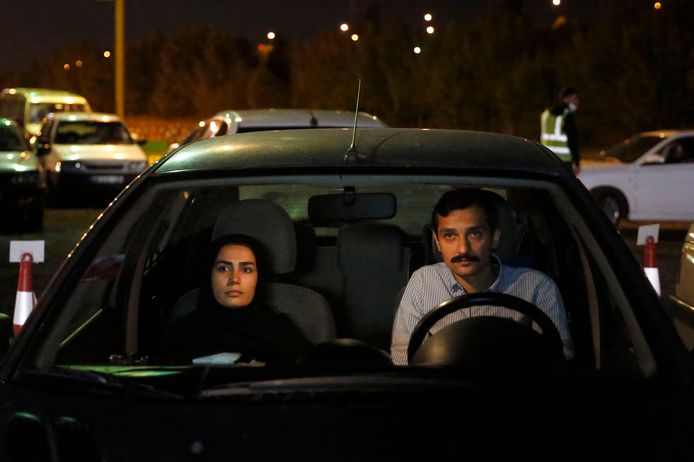 Iraniërs volgen vanuit hun auto een religieuze ceremonie in het kader van de ramadan.