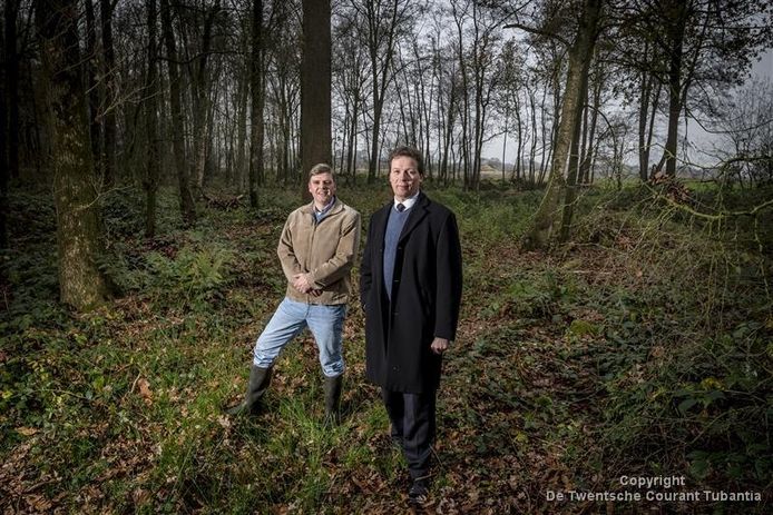 Uitvaartondernemer Jan Nijhuis uit Bentelo (rechts) en zijn landschapsadviseur Gertie Hissink staan in de open plek in het bos dat hoort bij de eerste natuurbegraafplaats in de provincie.