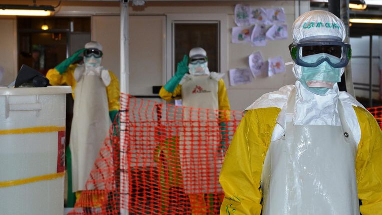 Artsen dragen beschermende kleding bij een behandelcentrum in Guinee. Beeld afp