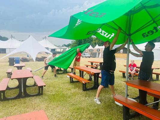 Parasols die gisteren nog dienst deden om toeschouwers te beschutten tegen de zon, worden nu uit voorzorg weggehaald.