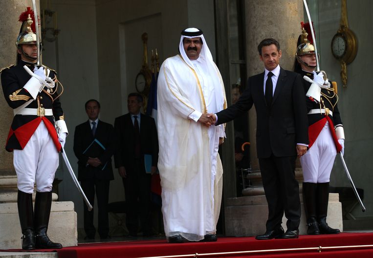 Nicolas Sarkozy schudt de hand van Qatar's Emir Sheik Hamad Bin Khalifa Al-Thani. Beeld Corbis via Getty Images