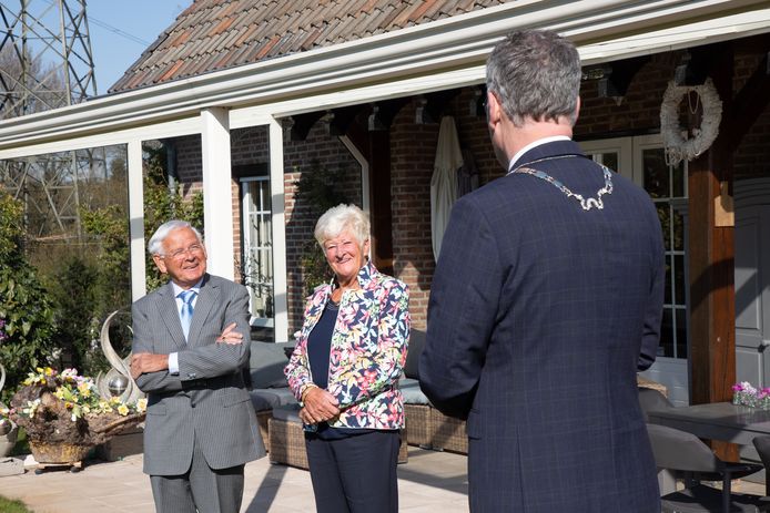 Burgemeester Hans Janssen verrast Piet Gelden in Moergestel met een lintje.