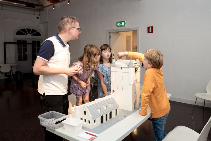 Corné Mol en zijn nichtjes Nora en Iris uit Zierikzee en bezoeker Bas uit Breda (vlnr) bouwen de Zuidhavenpoort na met lego  in het Stadhuismuseum in Zierikzee.