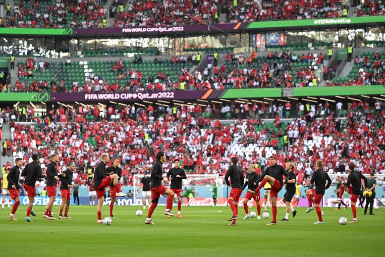 Het Deense elftal doet de warming-up in zwarte shirts. Beeld AFP
