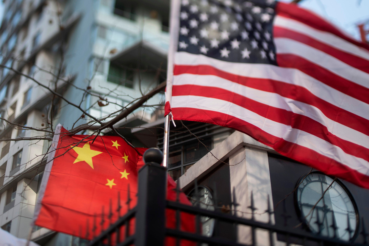 Een Chinese en Amerikaanse vlag bij een internationale school in Peking, China.  Beeld AFP, Fred Dufour