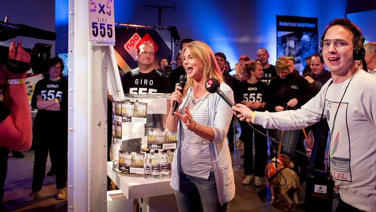 Presentatrice Pernille La Lau (L) maakt de vierde tussenstand van 6.411.027,60 euro bekend tijdens de nationale actiedag Nederland helpt Nepal in het 555-cafe in de Hallen. Beeld anp