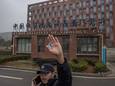 Een veiligheidsagent probeert te voorkomen dat foto's gemaakt worden van het virologie-instituut in Wuhan. Beeld van februari 2021.