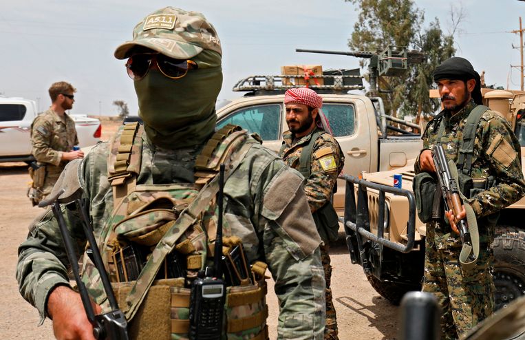 Leden van de Koerdische Syrian Democratic Forces (SDF) en Amerikaanse soldaten verzamelen nabij het olieveld Tanak voor een aanval tegen IS op 1 mei 2018. Beeld AFP
