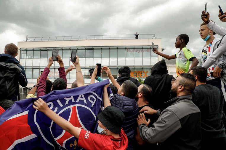 Voor de luchthaven van Le Bourget, bij Parijs, wachten supporters van PSG ongeduldig op de komst van Lionel Messi. Beeld AFP