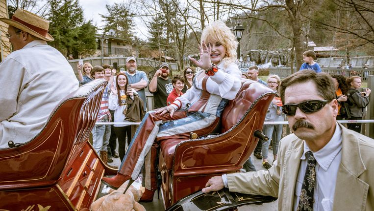 Countryster Dolly Parton, gehuld in kleding geënt op de Amerikaanse vlag, wordt rondgereden in een antieke auto in haar eigen Dollywood in Tennessee, ter ere van het 30-jarig bestaan van het park en de opening van het nieuwe seizoen. Beeld Jurriaan Teulings