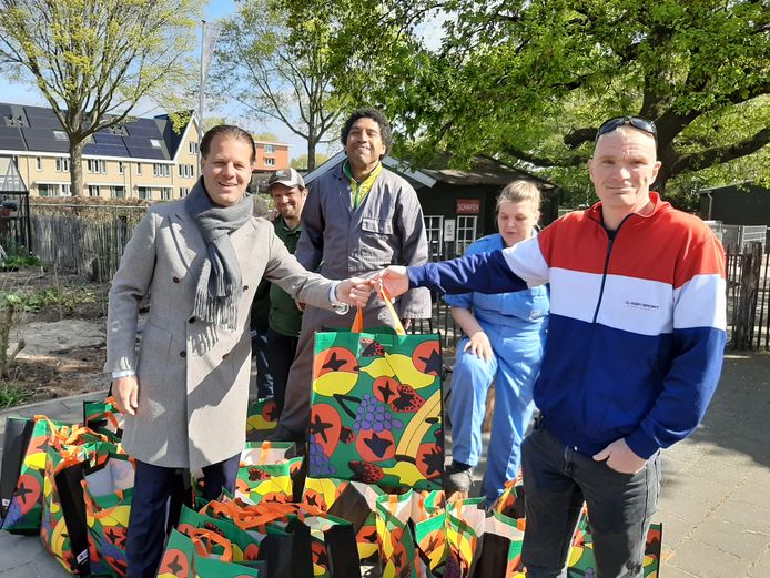 De getroffen bewoners van de verwoeste flat in Bilthoven krijgen een tas met kleine cadeautjes om ze ene hart onder de riem te steken. Danny Visser (l), directeur van de woonstichting SSW is er blij mee.