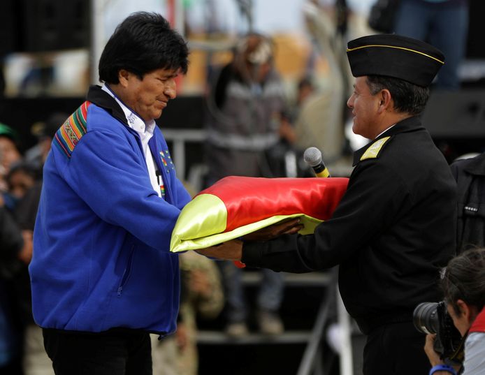 De Boliviaanse president Evo Morales geeft een vlag aan marinecommandant en admiraal Javier Ayllon tijdens de 'zeevlagdag' op 10 maart in Oruro.