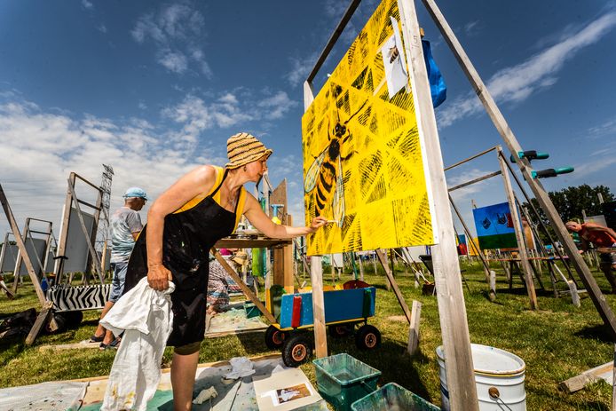 Een van de 450 kunstenaars die meewerkten aan The Colourfield Performance bezig met haar paneel. Het werd aan de buitententoonstelling is nu afgerond.