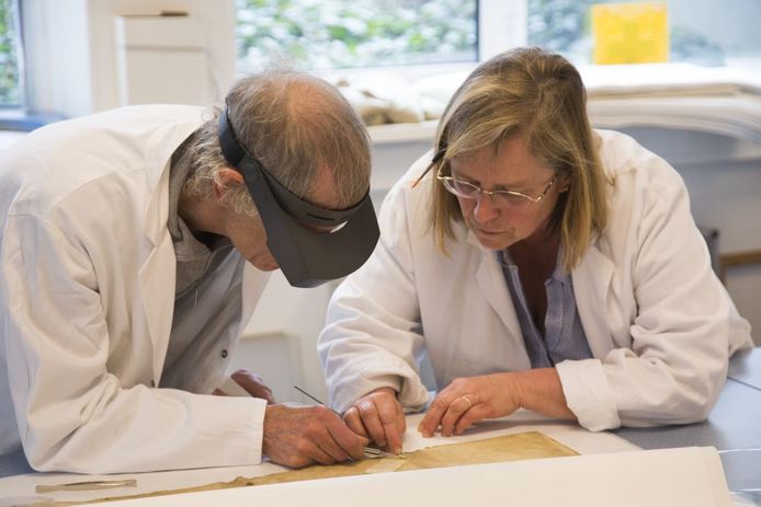Restaurateurs buigen zich over een eeuwenoud document en proberen het in ere te herstellen.