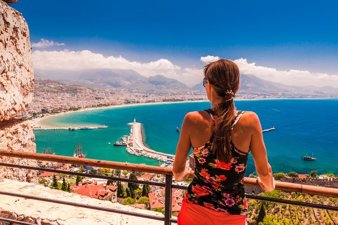 Een vrouw geniet van het uitzicht aan de kust van Antalya.