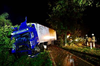 Truck rijdt bomen uit de grond en belandt in de sloot in Oeffelt