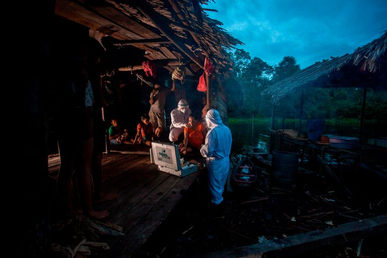 Zorgmedewerkers uit de stad Melgaco onderzoeken begin juni een vrouw met coronaverschijnselen uit een kleine dorpsgemeenschap op het eiland Marajó in Noord-Brazilië. Beeld Tarso Sarraf / AFP