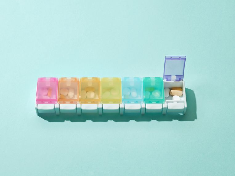 Coloured pill box with seven slots, one slot open. Beeld Getty Images/Science Photo Libra