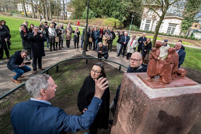 Rinus Morsink (links) legt ambassadeur Anick van Calster en burgemeester Roelof Bleker uit hoe hij Vlaamse Vluchtelingen heeft nagemaakt. De beeldengroep kreeg een prominentere plek in het G.J. van Heekpark in Enschede.