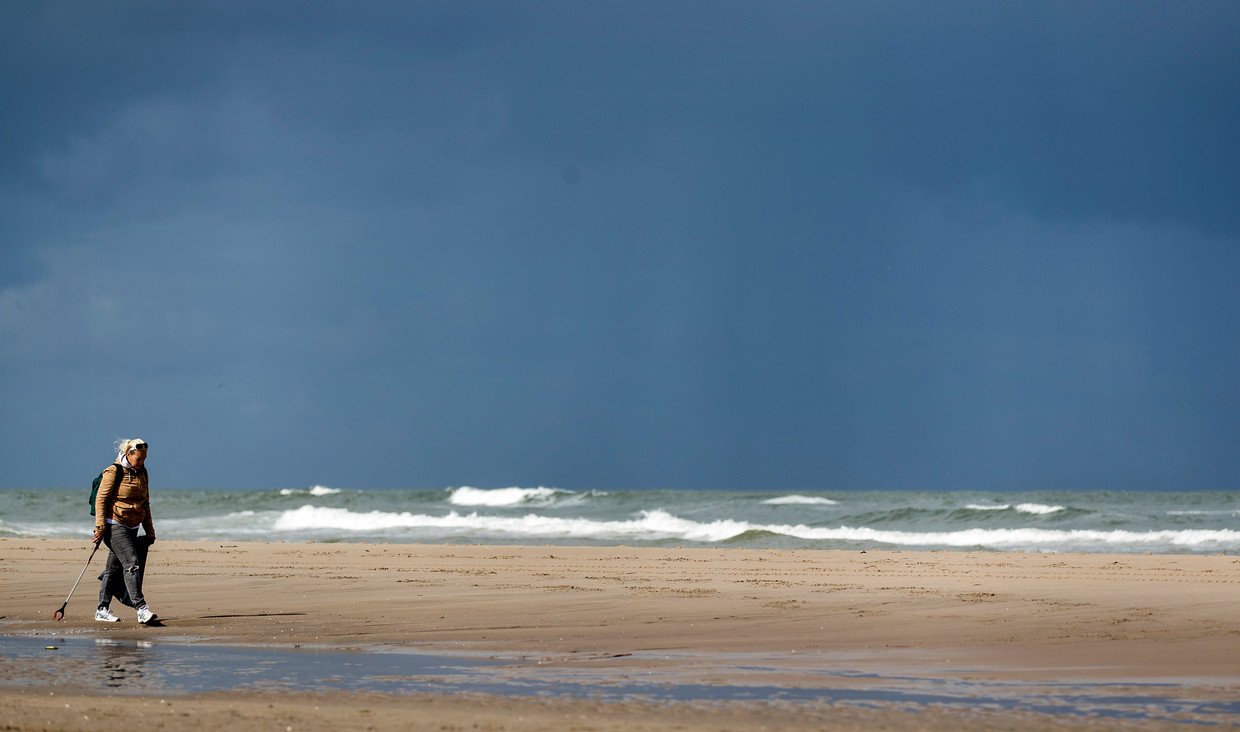 Vrijwilligers maken met Stichting De Noordzee de Nederlandse Noordzeekust schoon. Deze vrijwilliger is actief op het strand bij Monster.  Beeld Hollandse Hoogte /  ANP