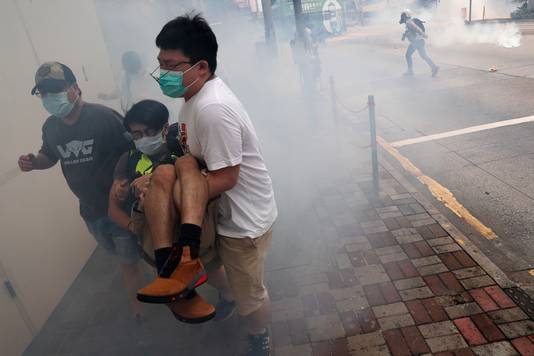 Demonstranten in Hongkong vluchten voor een traangaswolk.