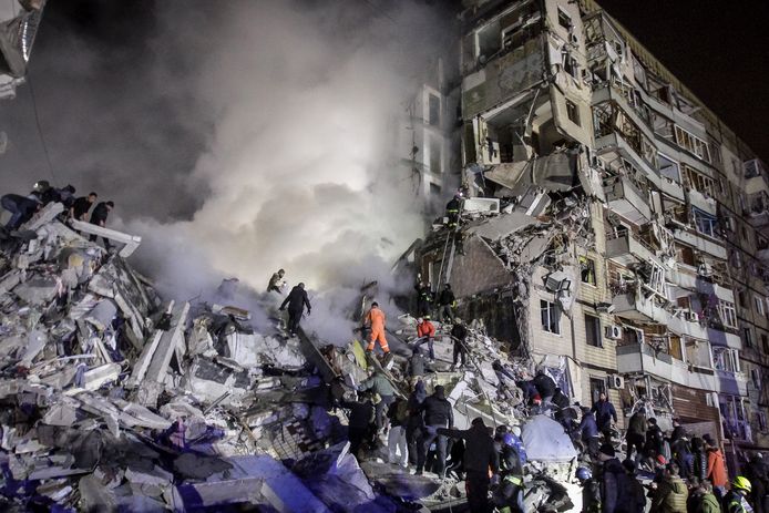 Inwoners helpen reddingswerkers bij het zoeken naar overlevenden van de raketaanval op het flatgebouw in Dnipro. (14/1/23)