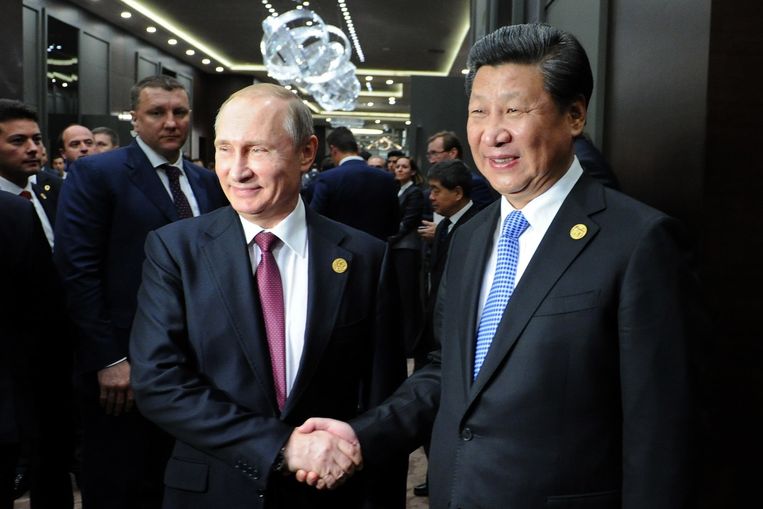 De Russische president Poetin schudt handen met de Chinese president Xi Jinping. Beeld anp
