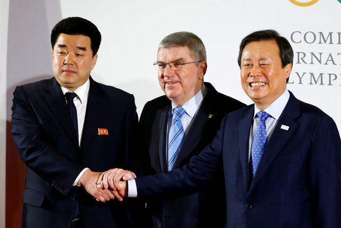 IOC-voorzitter Thomas Bach omringd door de vertegenwoordigers van Zuid- en Noord-Korea.