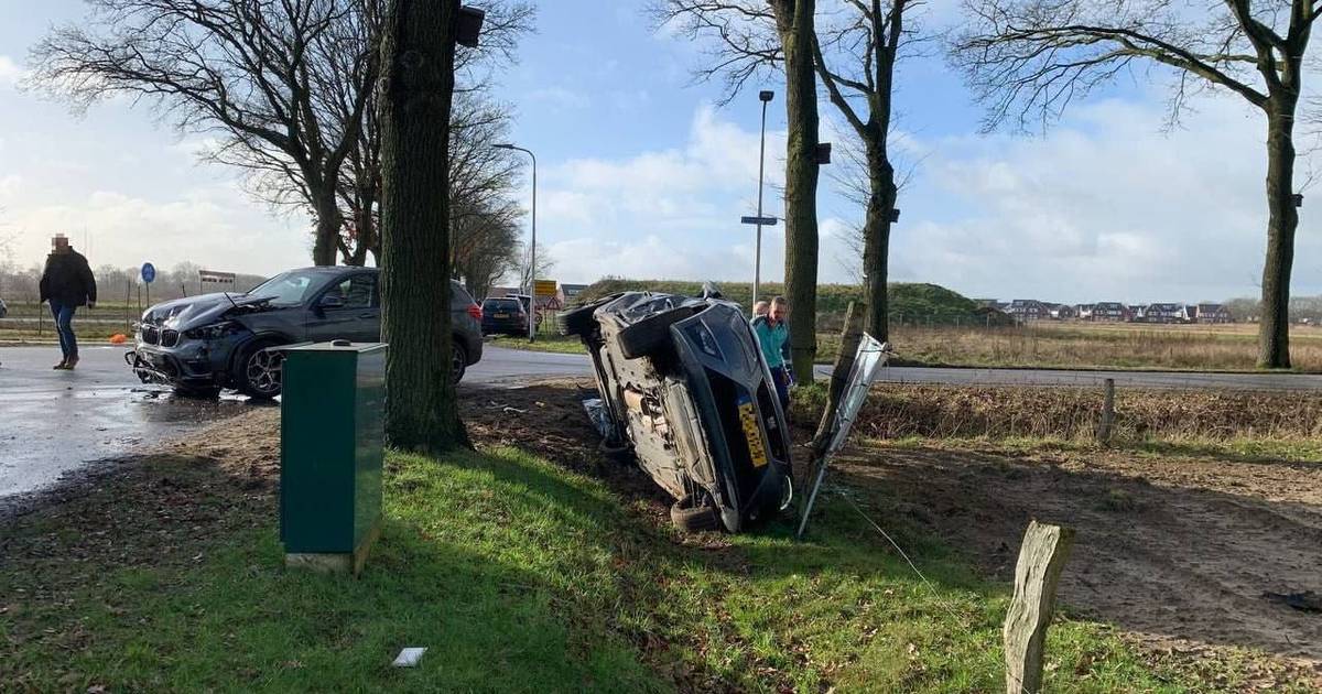 Bestuurder gewond bij botsing in Hardenberg, auto belandt op zijkant in berm.