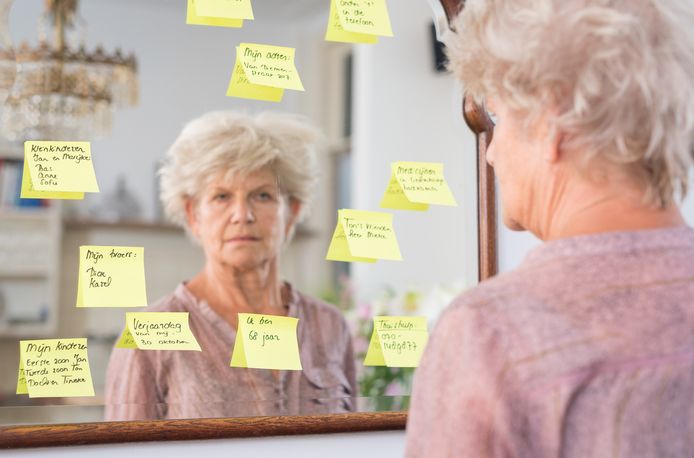Een oude vrouw bekijkt de notities op de spiegel. NB: de foto staat los van dit artikel