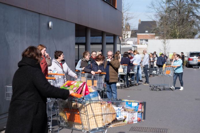 Mensen wachten in rij om te winkelen bij Colruyt in Sint-Katelijne-Waver.