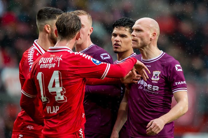 Spelers van FC Twente en Go Ahead Eagles maken ruzie in een verhitte wedstrijd.