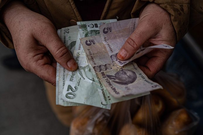 Een man telt Turkse lira.