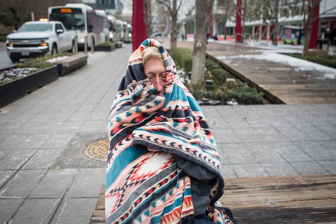 Een vrouw probeert zich in Houston, Texas warm te houden met een deken.