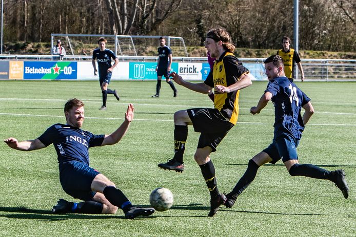 Davey Mooren van Diepenveen ontwijkt een sliding van Rick Janssen van Colmschate.