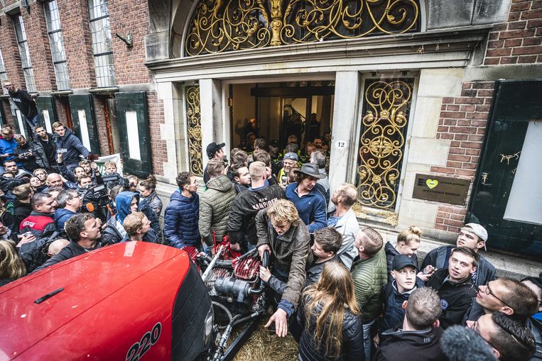 Boeren hebben de deur van het provinciehuis in Groningen er met een tractor eruit geduwd en zijn het gebouw binnengegaan. Beeld Siese Veenstra, ANP